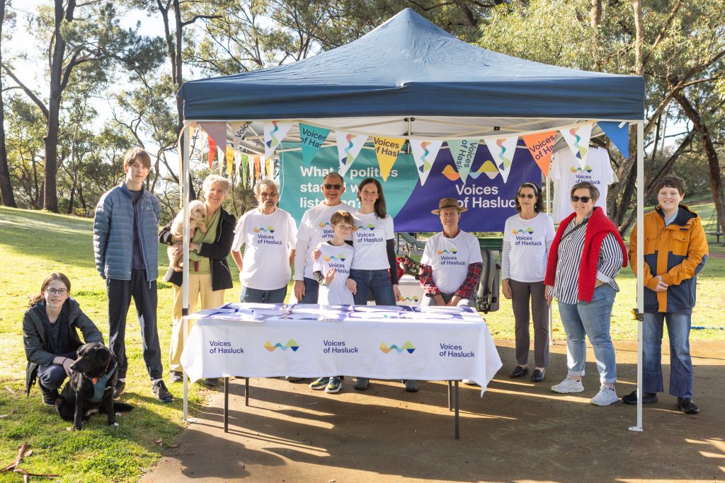 Photo shows a few Voices of Hasluck volunteers and local residents at a market stand.