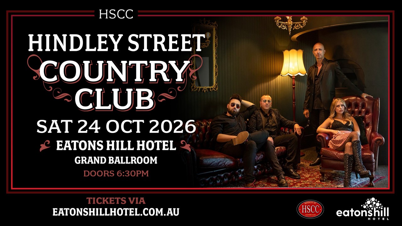 Band members lounging in a darkened room with floor lamp and event wording overlaid to left